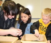 High School and Kindergartners looking at water sample